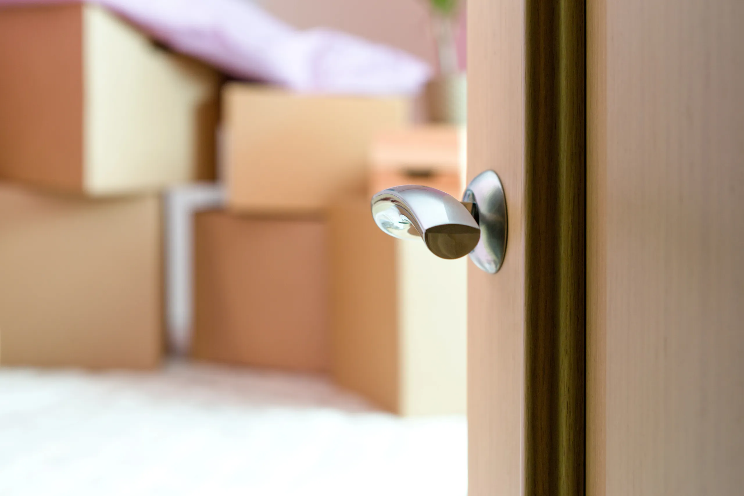 Moving boxes beside an open door, suggesting a new chapter in life.